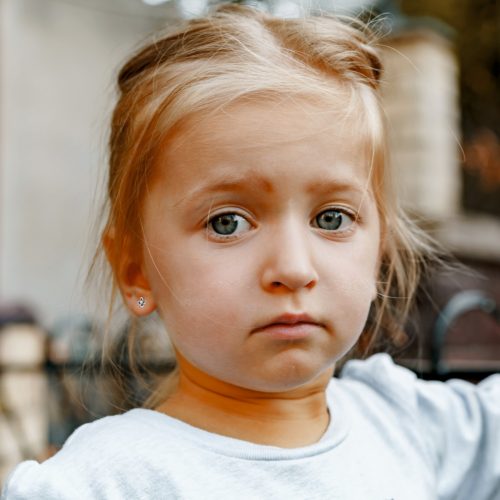 a close up of a girl with gold earrings